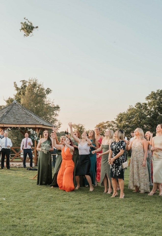 Bouquet toss on the lawn