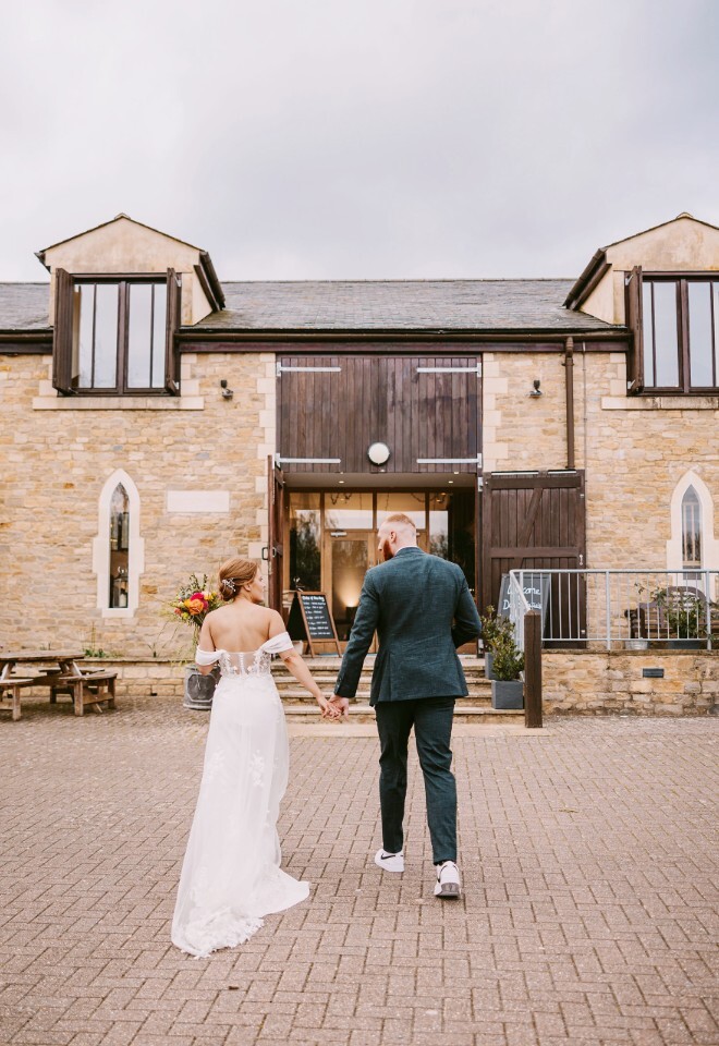 Bride and Groom walking into Worton Hall wedding venue