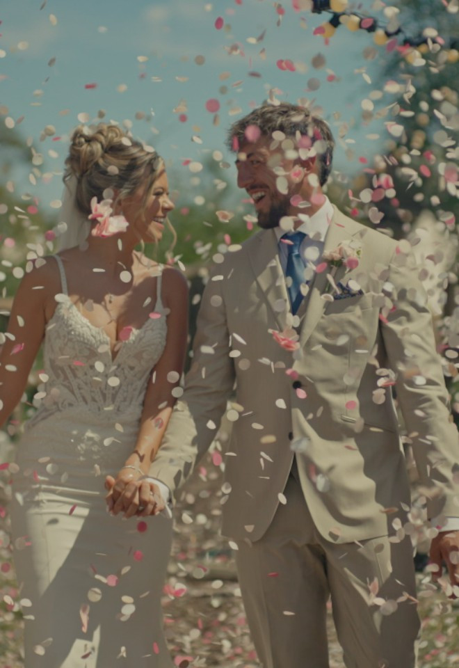 Image 10: Bride and groom walking through confetti at De Vere Latimer Estate, Buckinghamshire, captured by Dean Sherwood Wedding Films, Hertfordshire wedding videographer.
