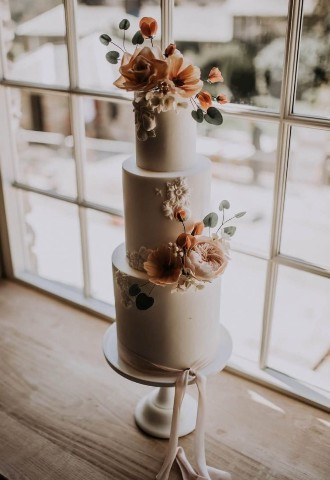 Three tier cake with orange flower details designed by Wren Cake Designs and photograph taken by Mindy Coe Photography