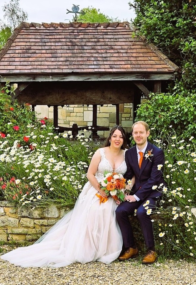 A couple surrounded by flowers in the springtime at Yarlington Barn Weddings