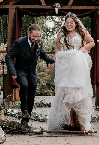 Handfasted couple jumping the broom