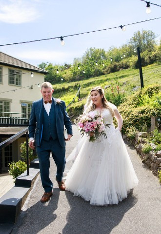Bride arriving at her wedding ceremony at Bickley Mill Inn, Devon