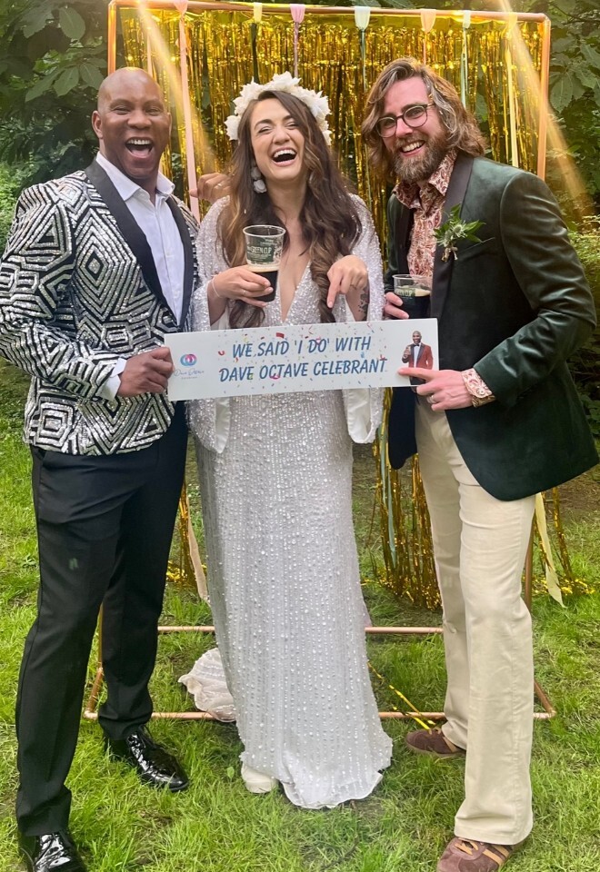 Dave Octave Celebrant with a happy bride and groom smiling and holding my We said I Do with Dave Octave Celebrant sign.