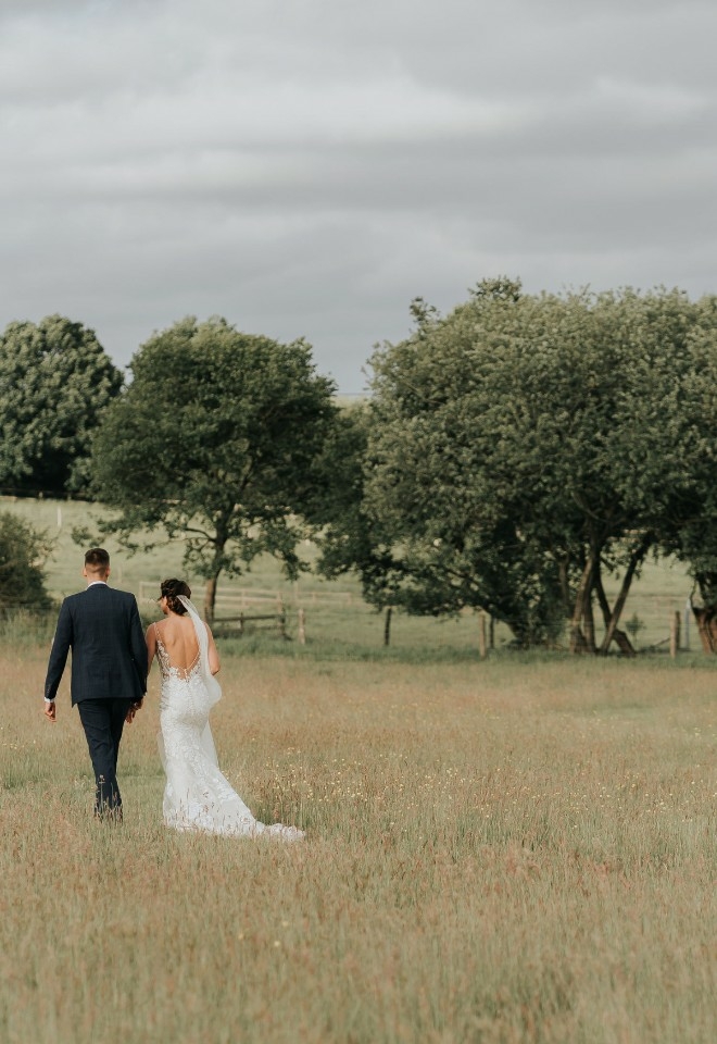 Married couple walking through the field at Silchester Farm