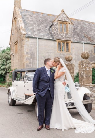 Couple pose outside Midelney Manor Wedding Venue