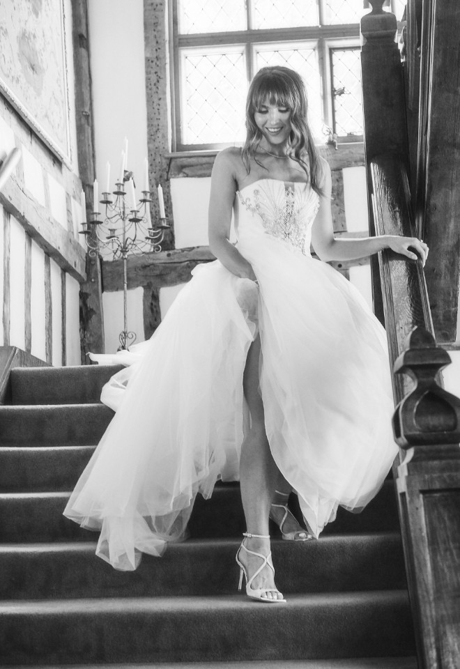 Ballingdon Hall wedding bride walking down the stairs in shimmering ivory dress and jimmy choo shoes by Stuart Wood