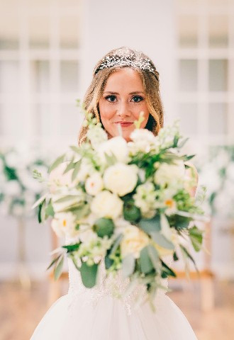 Bride holding bouquet in Posy and Pearl Bridal gown