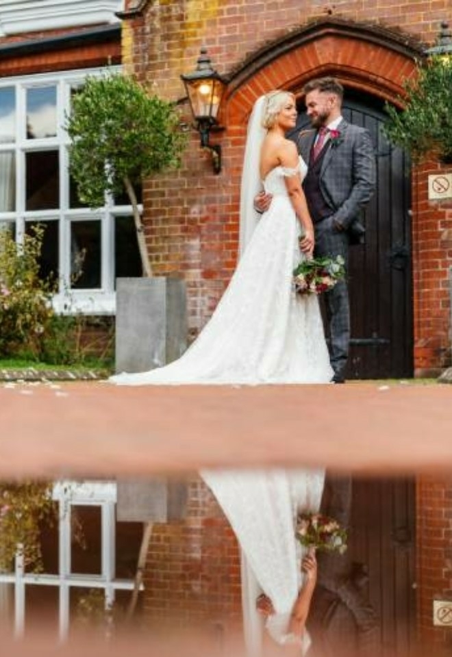 Couple standing together outside the Manor door with puddle reflecting the image- Sprowston Manor Norwich