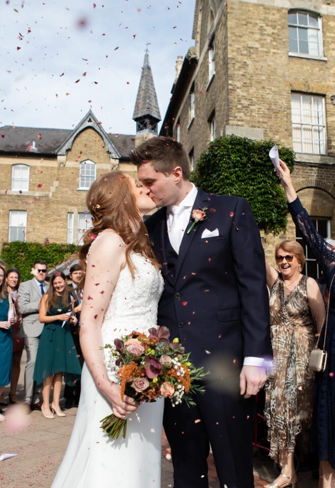 Wedding Photographer Bucks, bride and groom kissing in confetti 