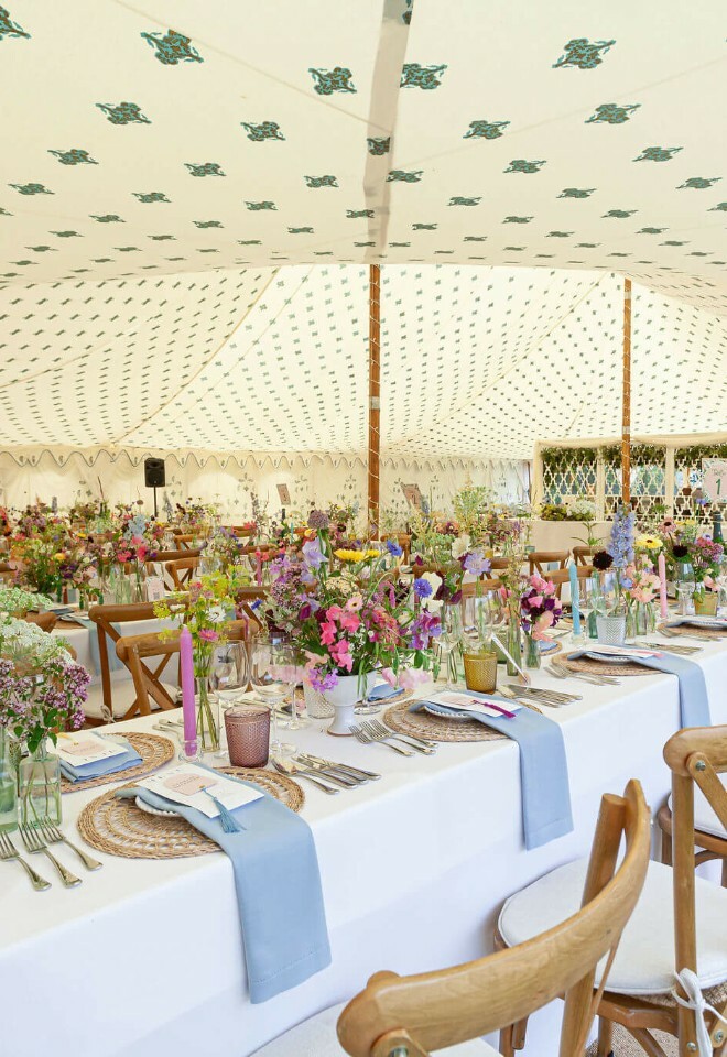 Luxury marquee with cornish cream linings and banquet dinings tables covered in floral arrangements 
