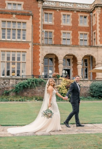 Bride and Groom holding hands outside Easthampstead Park