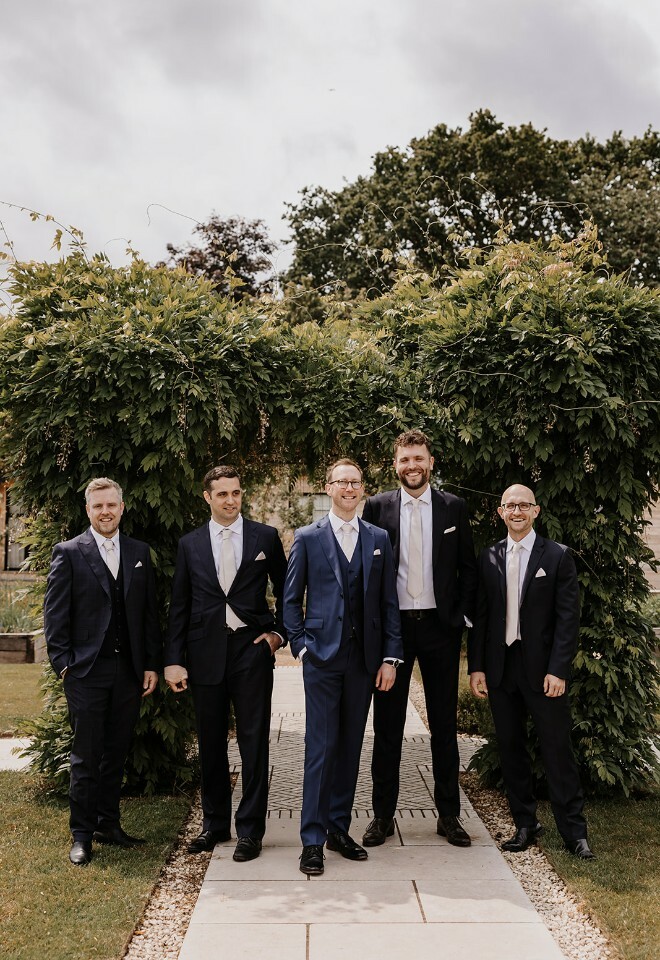 Groom and groomsmen under wisteria