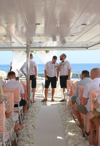 groom and groomsmen wait at the altar, on a yacht, for the bride