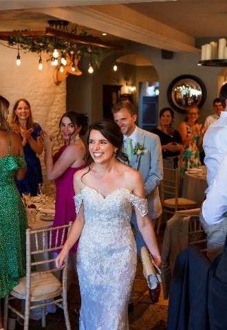 Bride and groom walking into their wedding reception at The Bay Tree Hotel, Burford, Oxfordshire