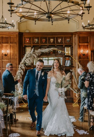 Bride and groom leave their wedding ceremony at Chateau Rhianfa, North Wales