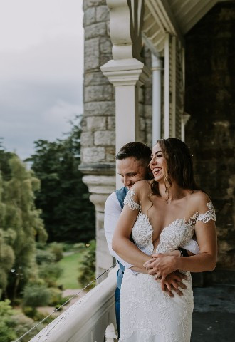 Bride and groom on a balcony at Chateau Rhianfa, Anglesey
