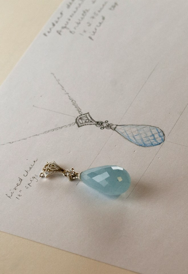 bespoke aquamarine wedding pendant on top of sketch