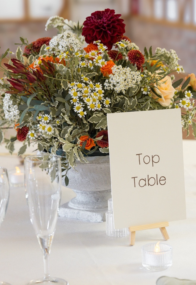 Orange flowers in urn arrangement on table