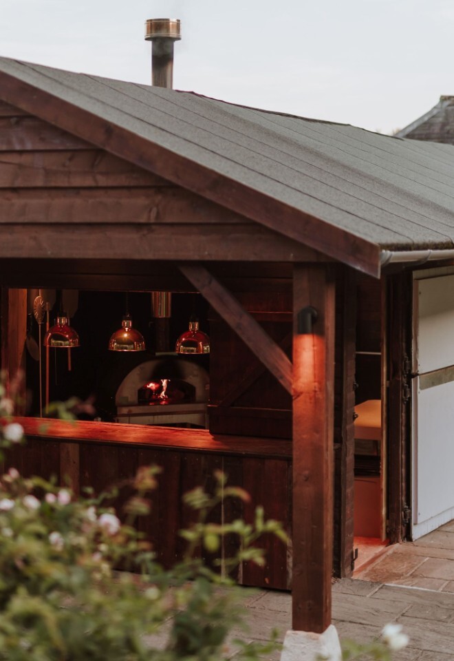 An outdoor kitchen to cook delicious pizzas at an Oxfordshire Barn wedding venue