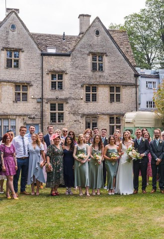 Bride, groom and wedding guests stand for group photo outside of Egypt Mill