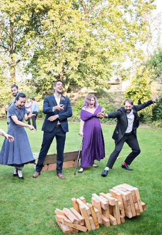 Guests playing giant jenga in the gardens at The Bay Tree Hotel, Burford, Oxfordshire