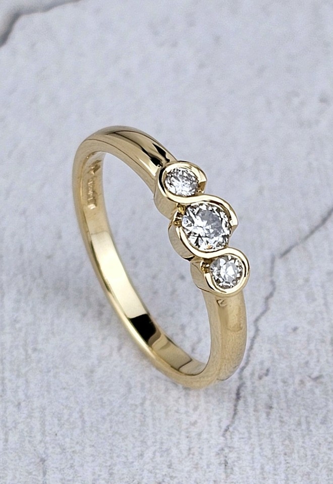 gold ring with diamonds three-stone ring with a serpentine setting.