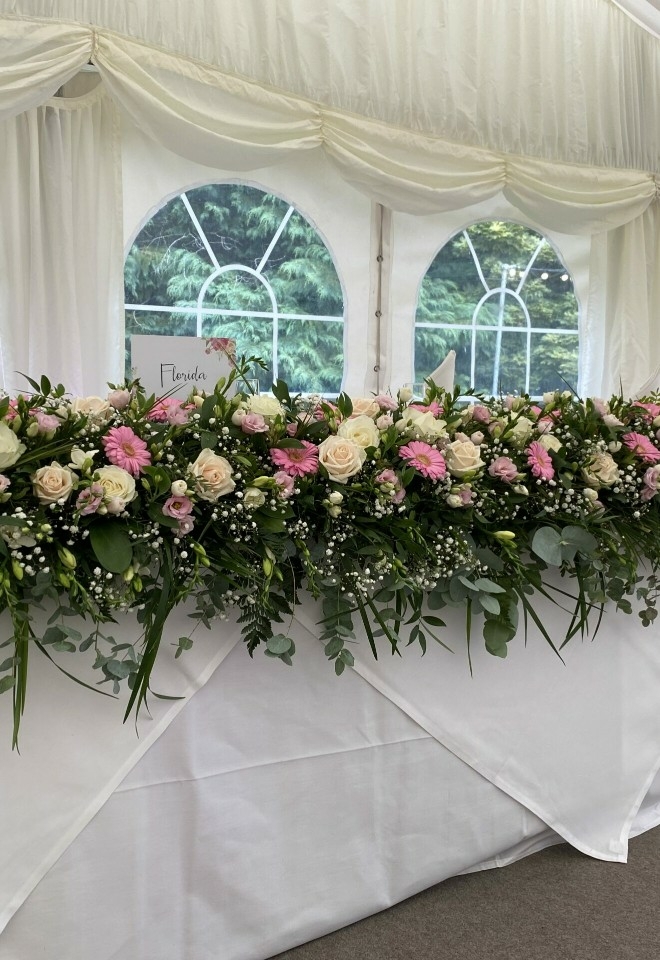 pink, white and cream flower display on table by hire heaven