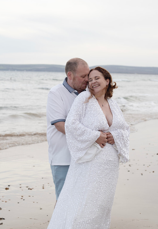 “Bride and groom embracing on Bournemouth beach near The Orchid Hotel Dorset wedding”
