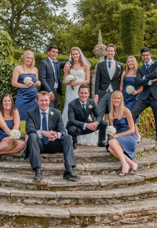 Bridal party pose on garden steps at Weston Manor, Oxfordshire