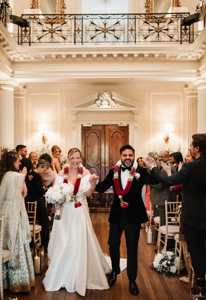 Multifaith couple leaving their celebrant wedding ceremony at Hedsor House Buckinghamshire
