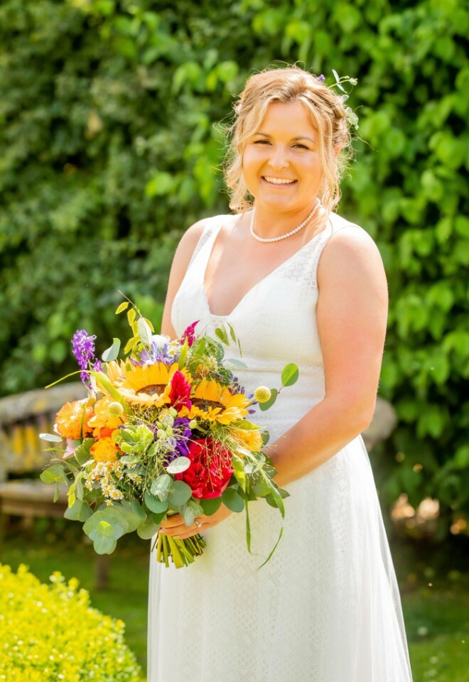 bride holding bouquest with sunflowers, peonies & bright vibrant wedding flowers, created by Oops a daisy Cirencester