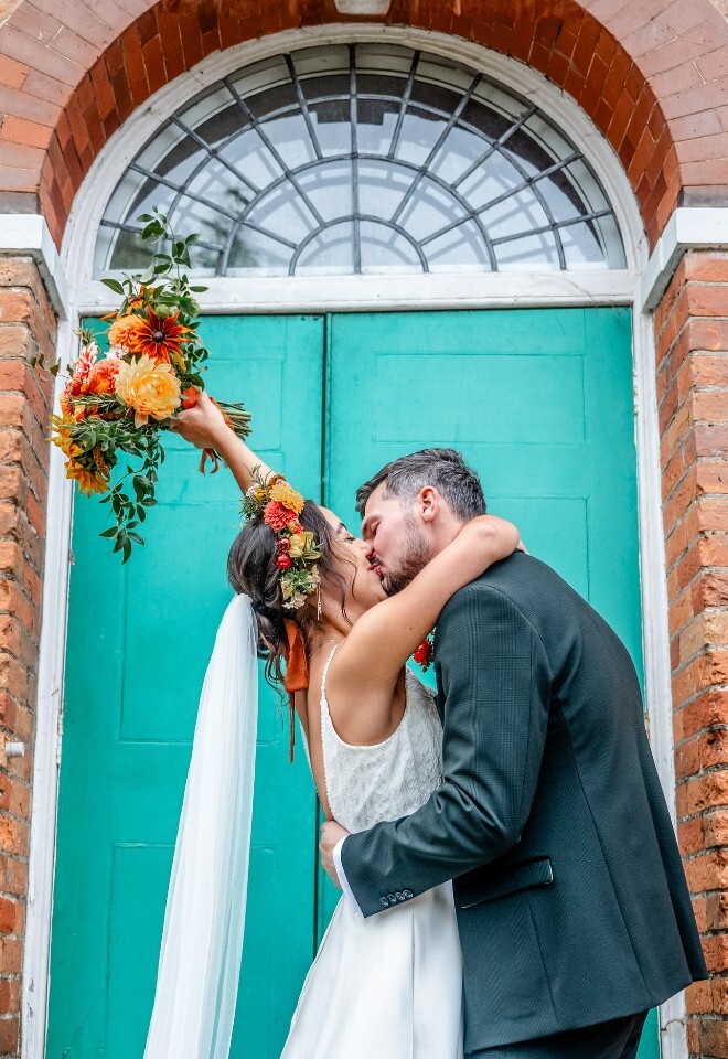 Couple photo in front of the green doors 