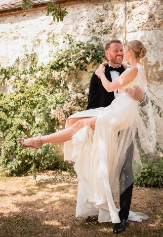 Groom lifting a bride in her wedding dress