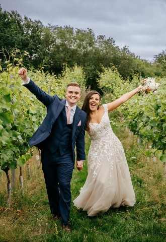 Wedding couple posing in the vineyard at High House wedding venue in Essex