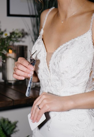 Bride hold card and fork that Ben has manipulated during close-up magic trick