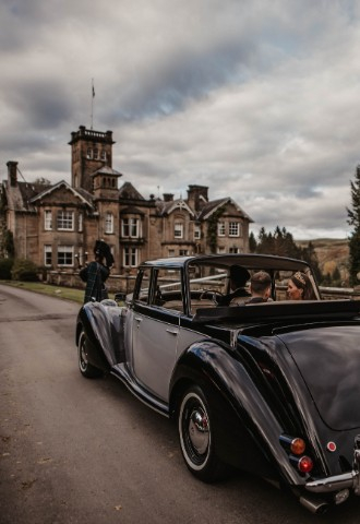 Wedding car approaching Auchen Castle - a romantic castle wedding venue in Scotland