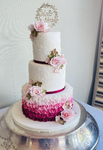 Three tier pink wedding cake with sugar flowers and Cake toppermade by Celebration Cakes by Catherine Scott in Berkshire