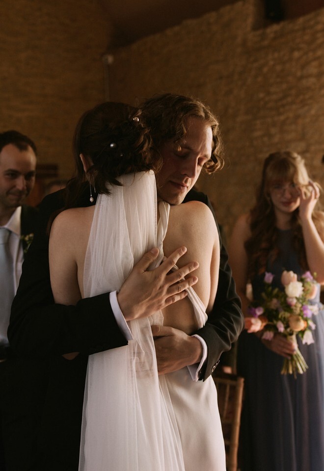 Emotional wedding couple hug after being married by UK wedding celebrant
