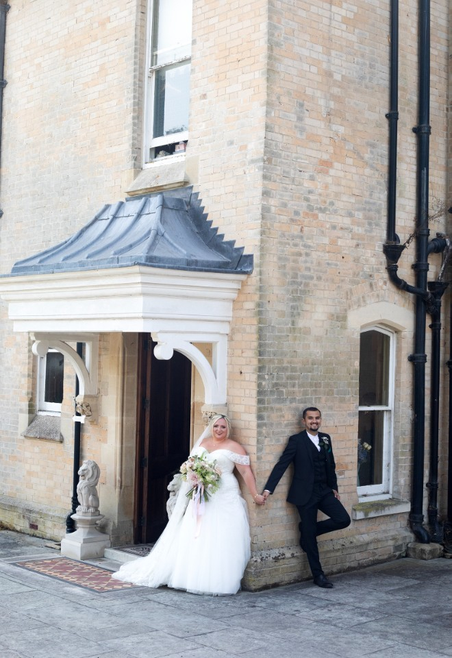 a bride and groom having a first touch, standing at the corner of Radipole Manor and stealing a few moments before they see each other in the ceremony room.