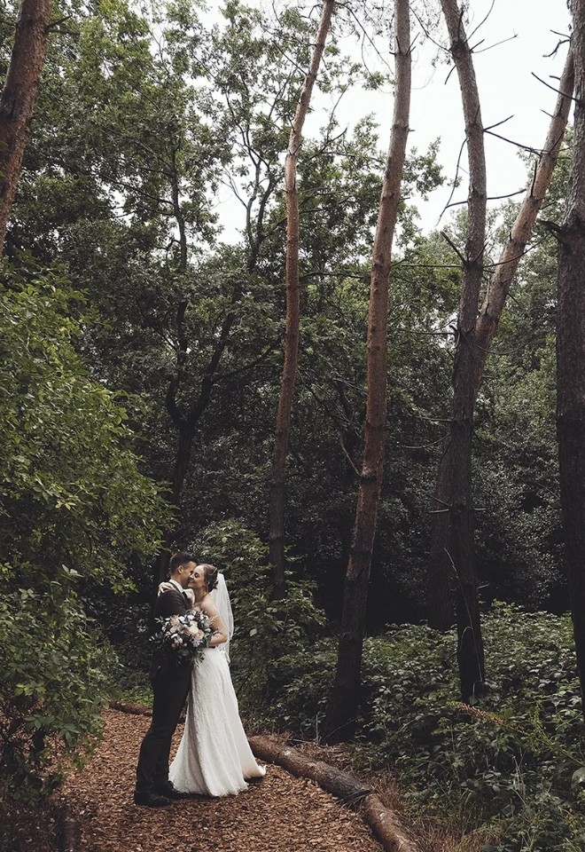Bride and groom hug in Woodland