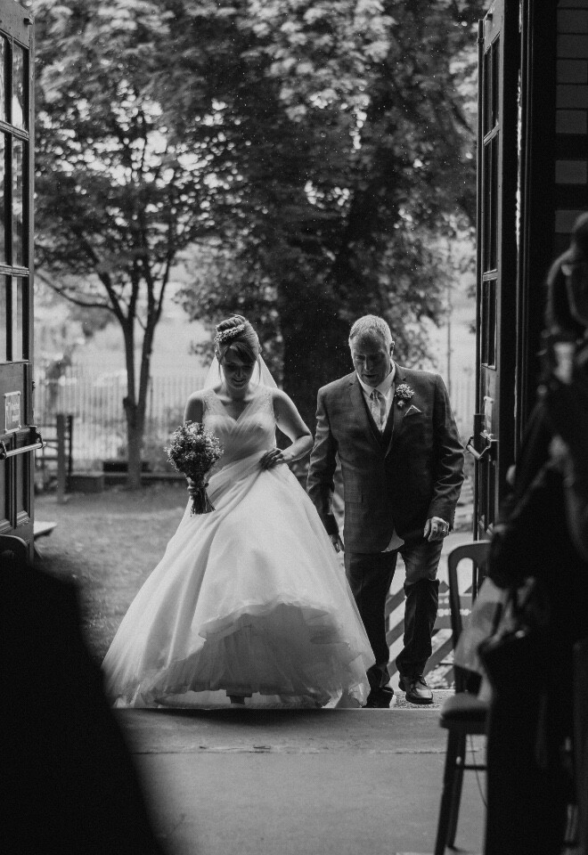 Bride arriving at wedding ceremony captured in timeless black and white documentary style