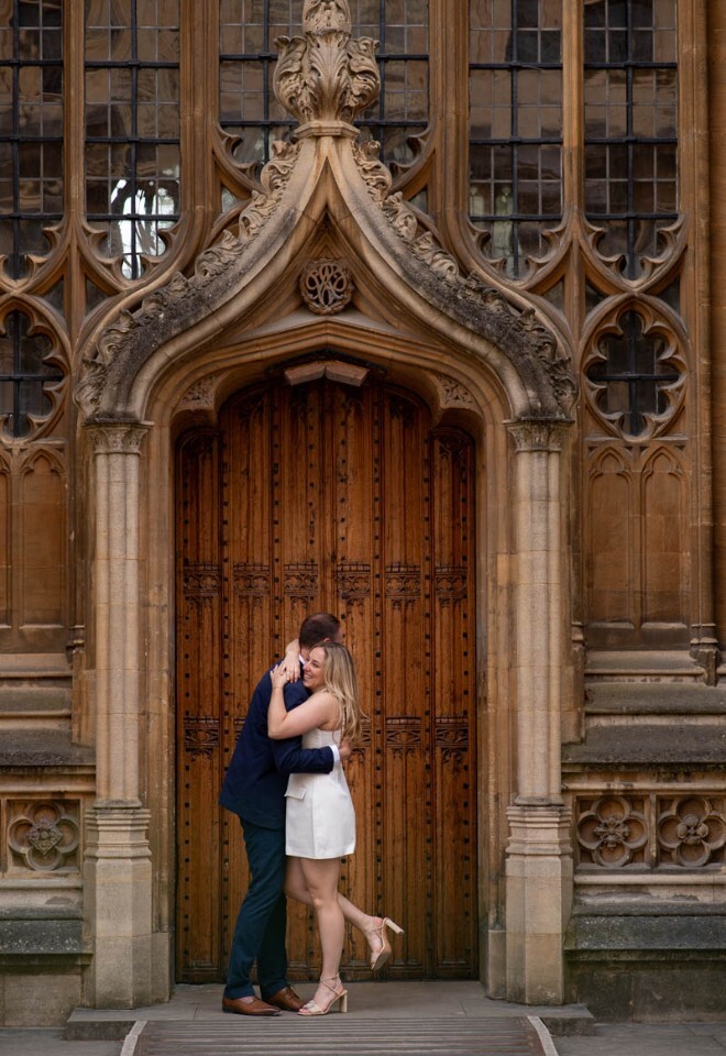 A newly engaged couple celebrate outside the Bodleian Library.