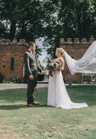 Bride and groom pose whilst the veil floats in the wind, Matt Clarke Photography