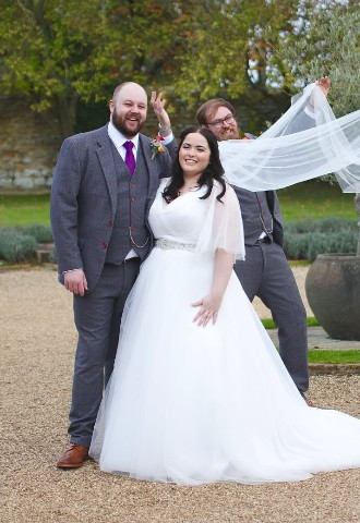 Dodford Manor bride and groom pose whilst the groomsmen adjust the veil, SMD Wedding Photography, West Midlands