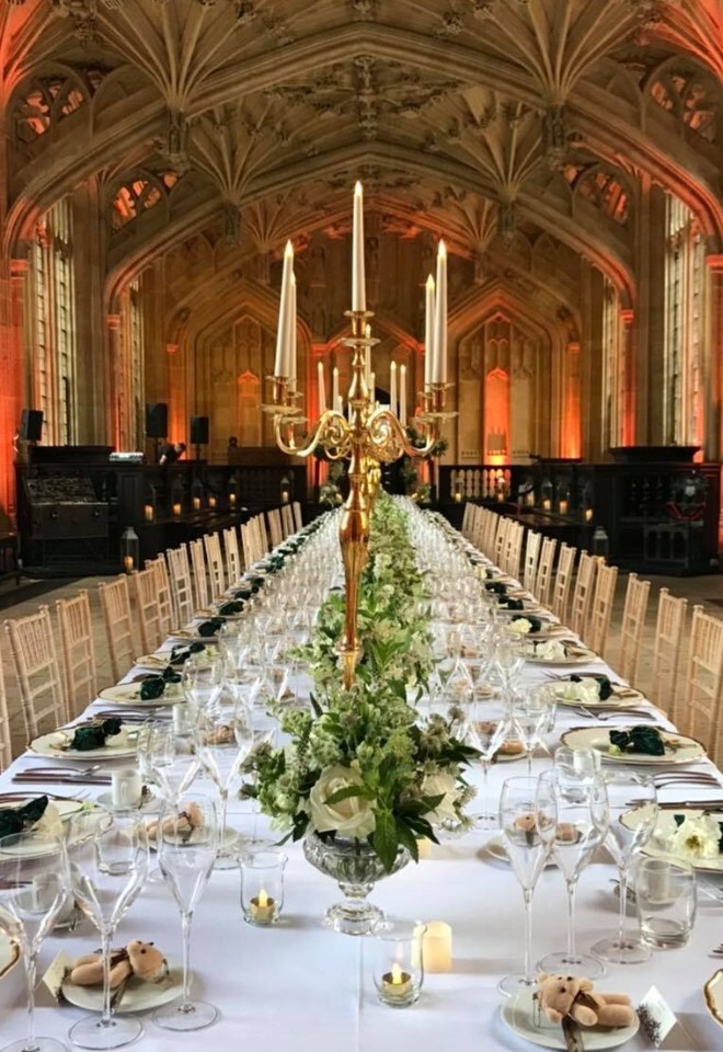 long table inside church with large candle holder as centre piece