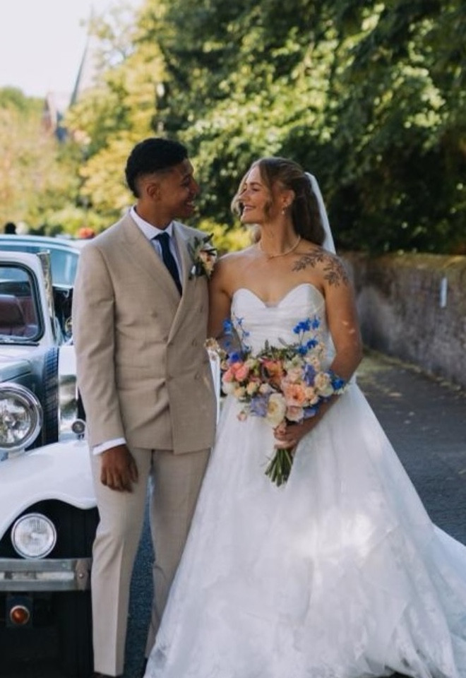 Bride and groom outside wedding car