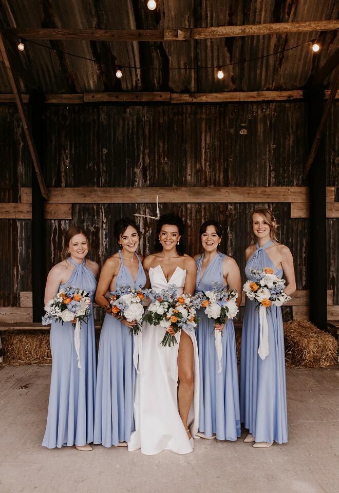 Bride and bridesmaids under dutch barn