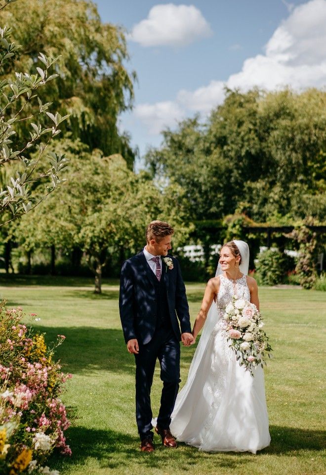 Wedding couple walking in the grounds at High House wedding venue in Essex