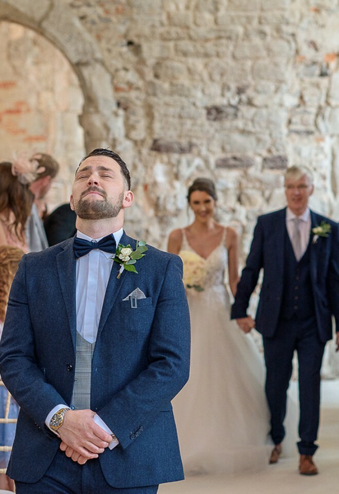 groom at the alter waiting for his bride to walk down the aisle with her father. wedding in dorset